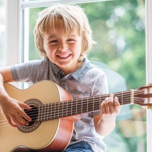 Agoura Hills young child plays guitar at home